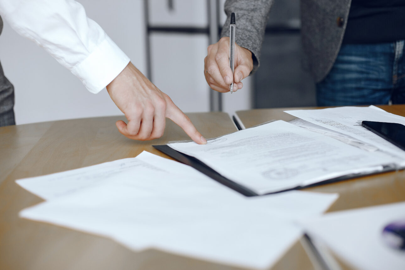 Two people signing a document